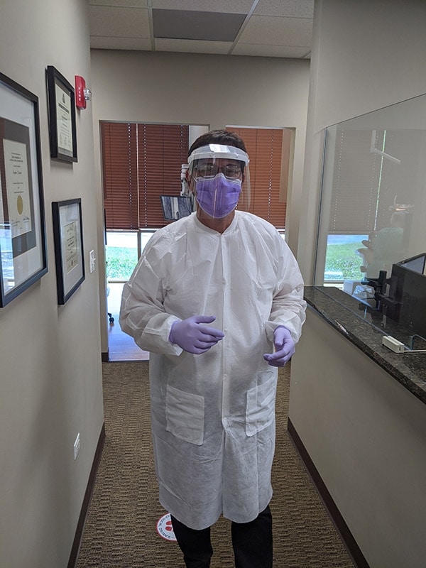 Dr. Stephen Lavrisa is donning PPE to maintain infection prevention